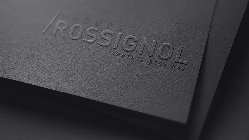 logo Groupe Rossignol Gros plan d'une couverture de magazine noir avec un logo embossé en ton sur ton